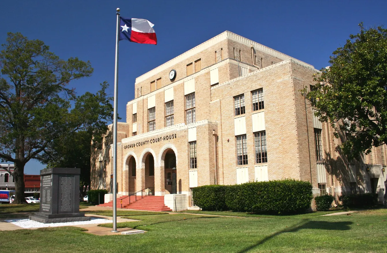 Texas county courthouse with flag flying, sunny day.